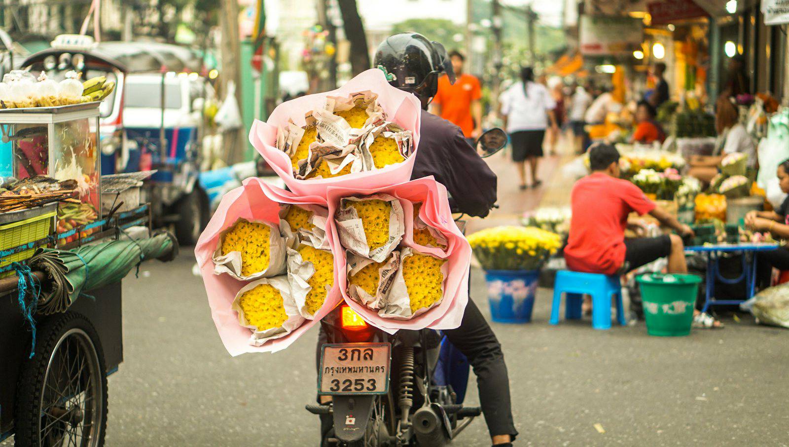 Motorbike carrying flowers through a Bangkok flower market