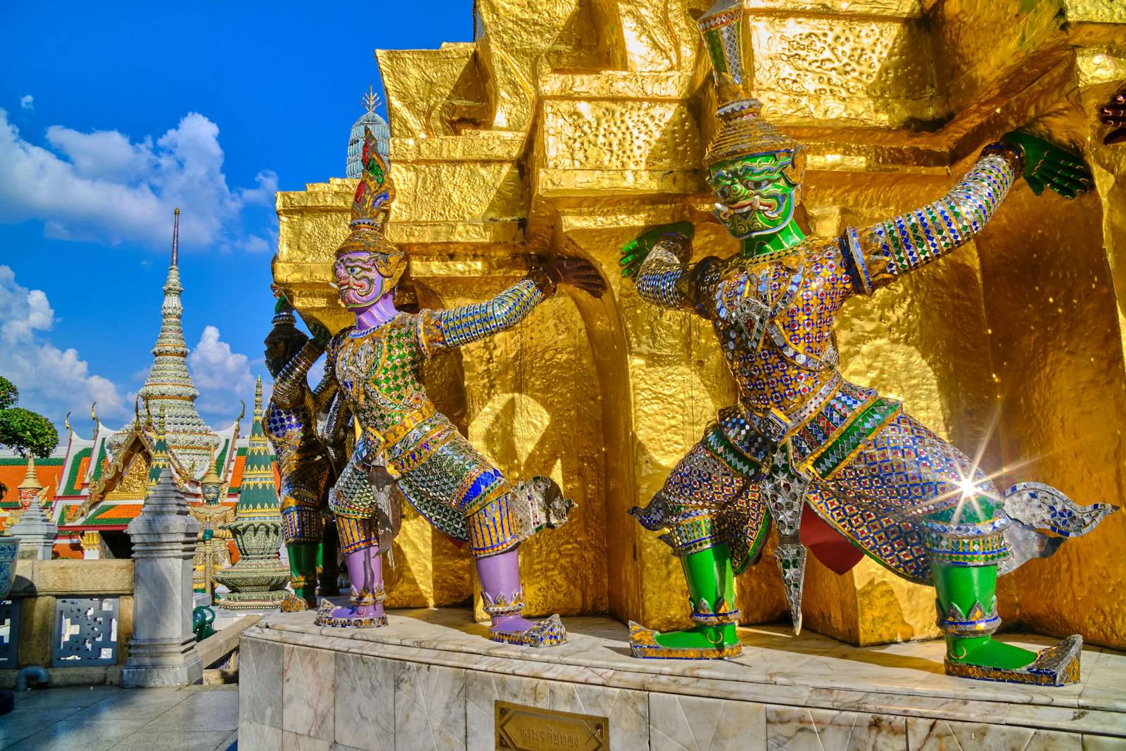 Guardian statues around a golden chedi at the Grand Palace in Bangkok