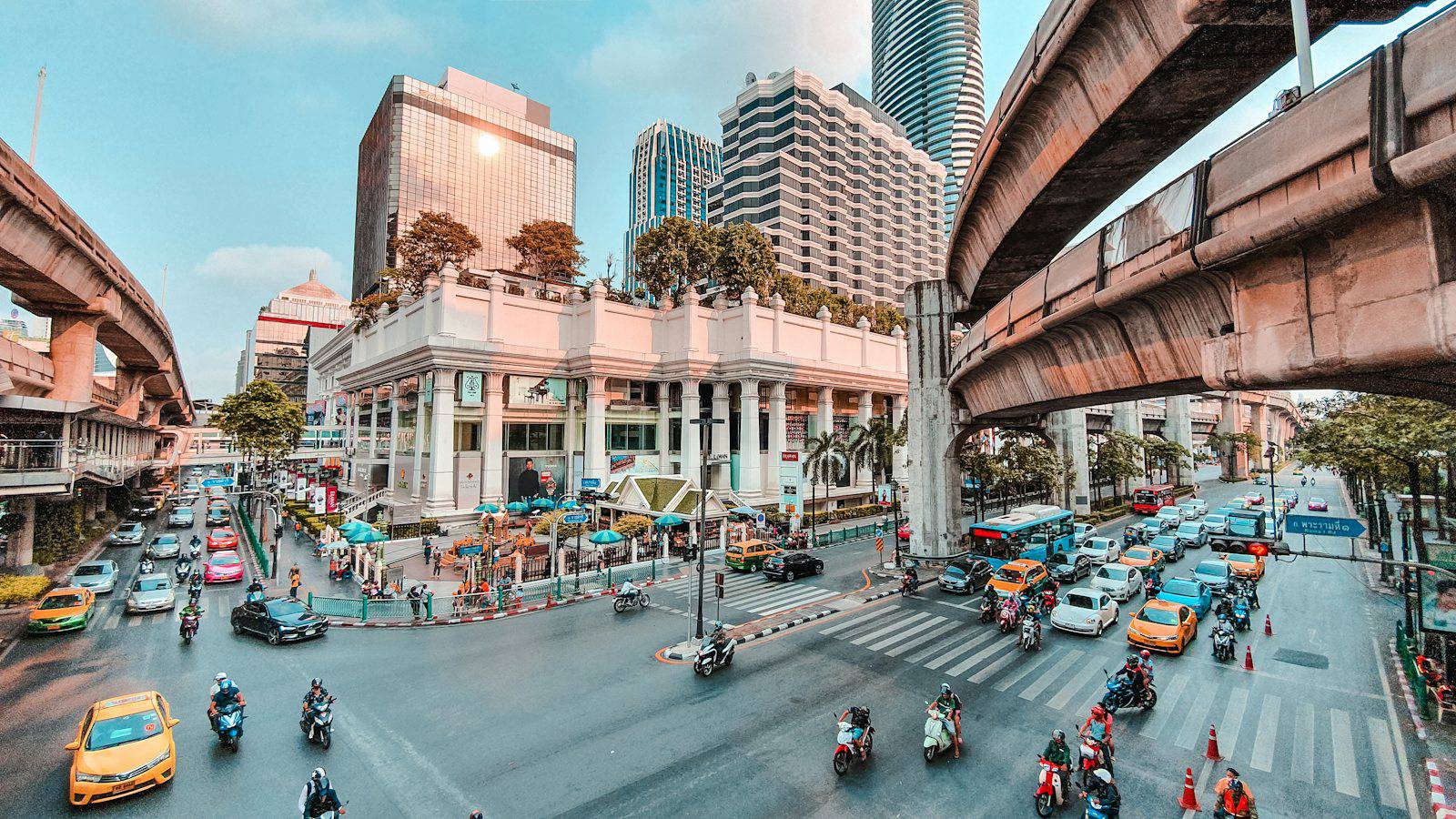 Busy Bangkok intersection with traffic below the elevated train line