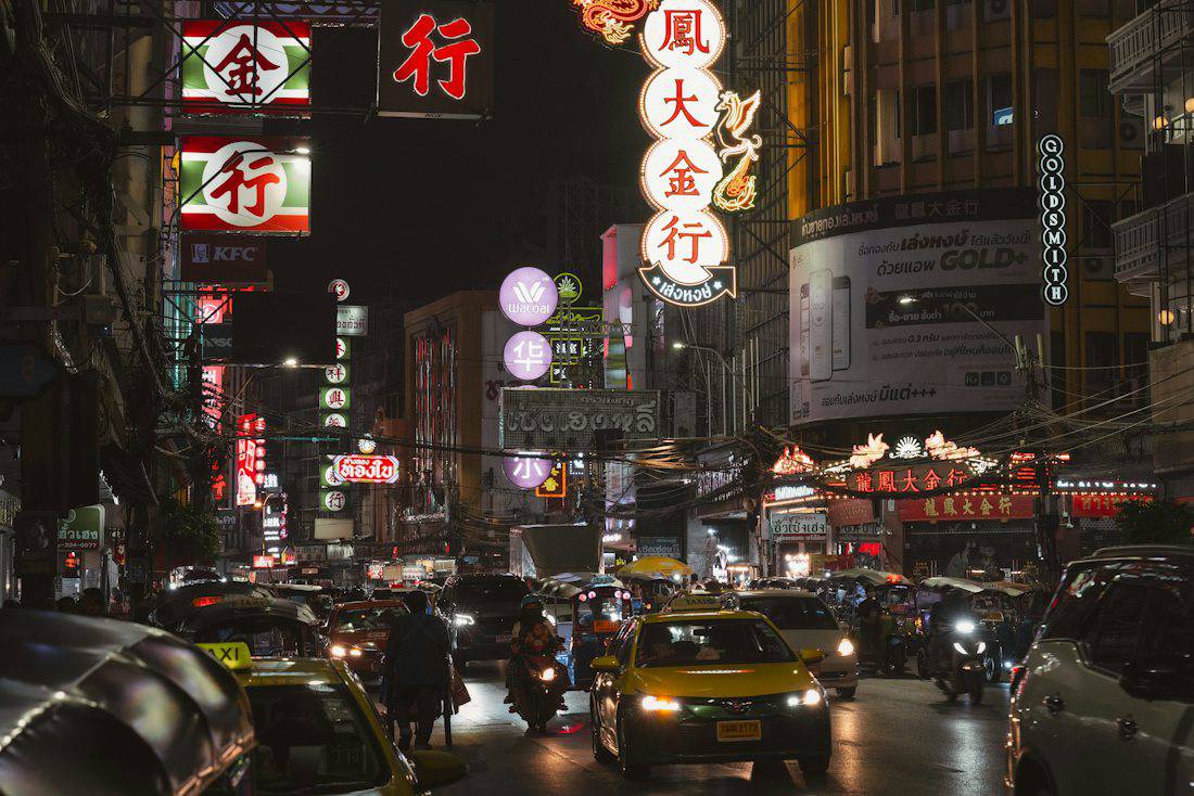Neon signs and evening traffic on Yaowarat Road in Bangkok