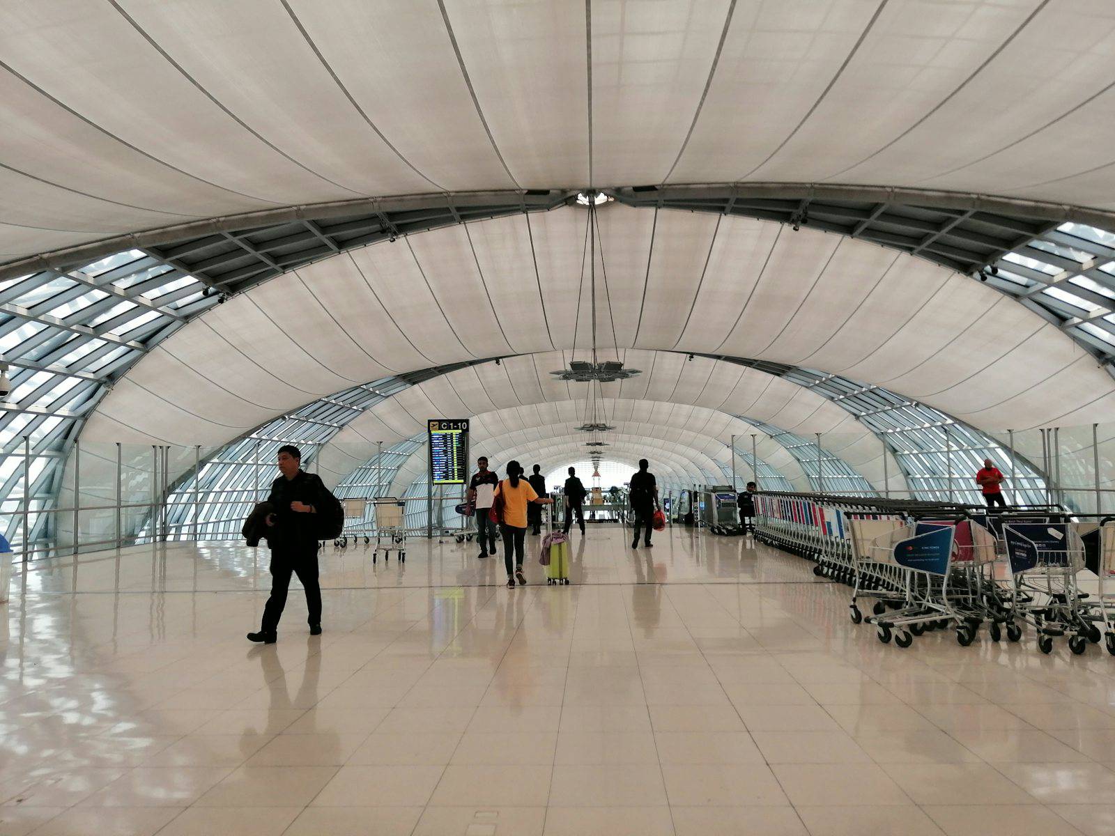 Travelers walking through the Suvarnabhumi Airport terminal