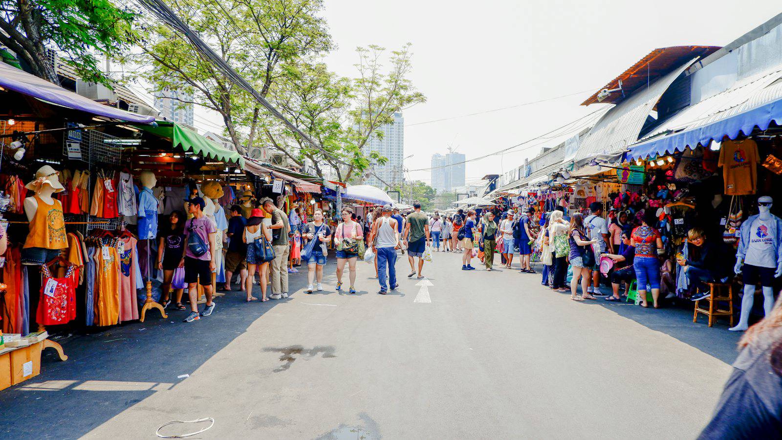 Shoppers walking through Chatuchak Weekend Market in Bangkok