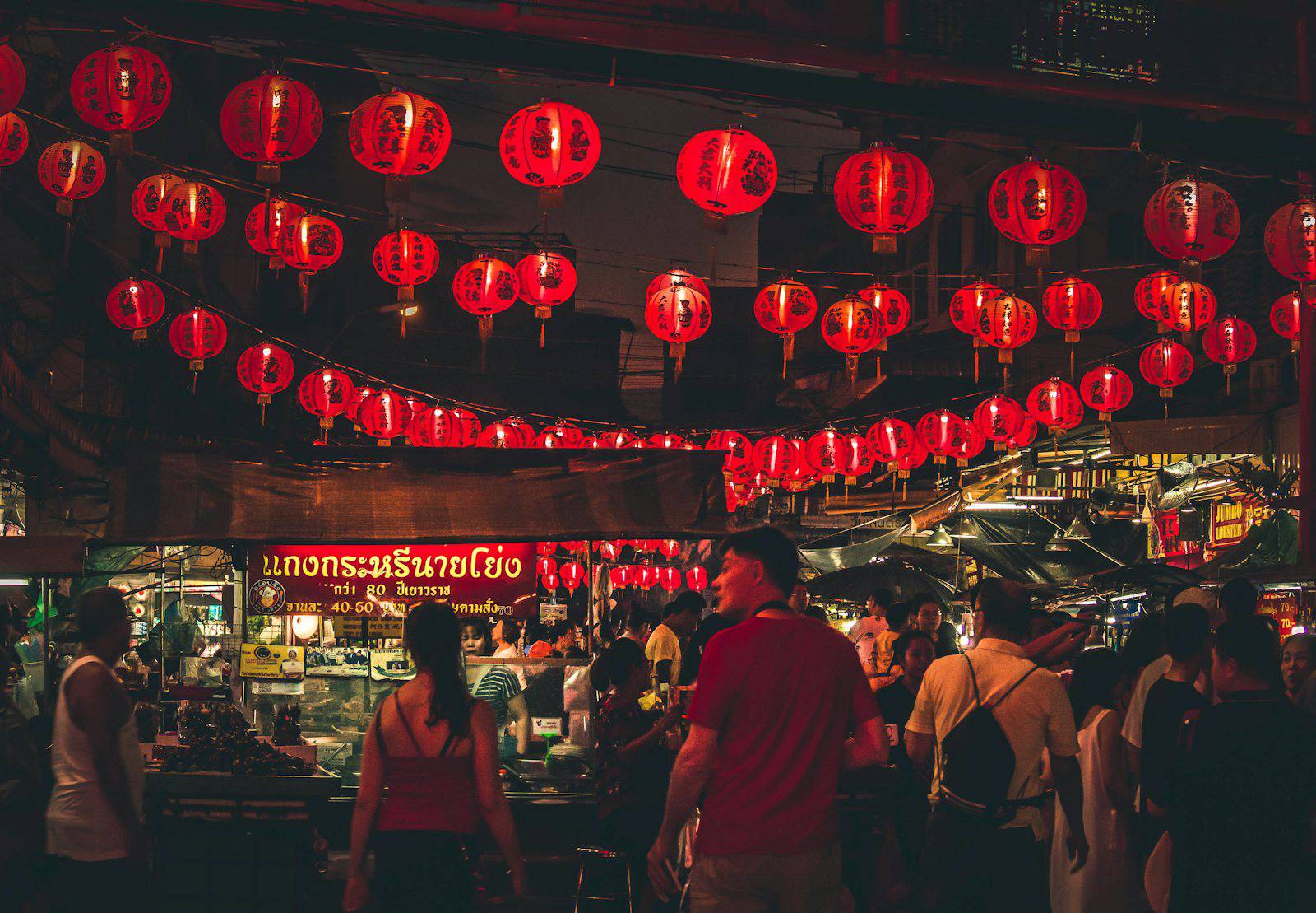 Red lanterns above a crowded night market in Bangkok Chinatown