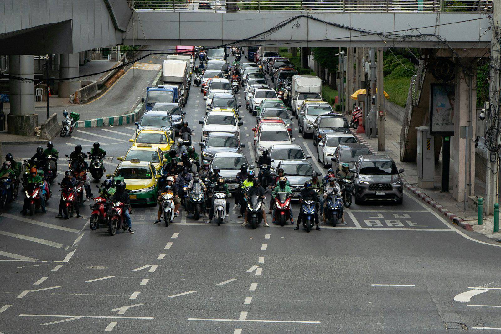 Motorbikes and cars waiting at a Bangkok intersection