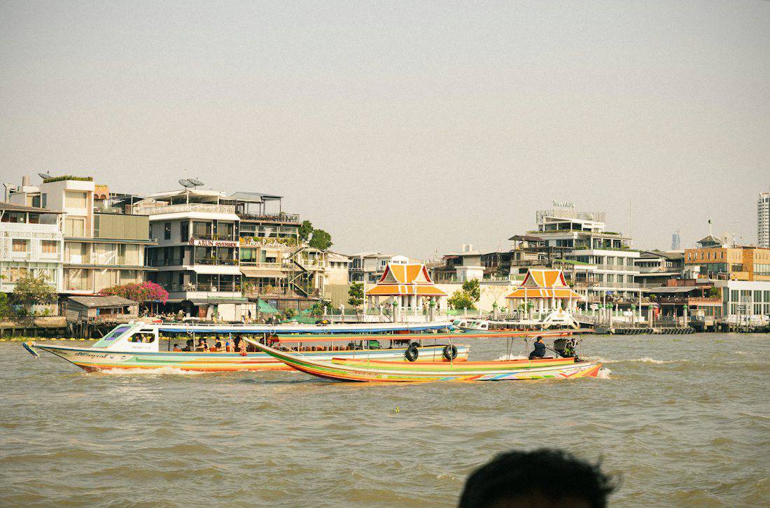 Riverside houses and long-tail boats on the Chao Phraya River