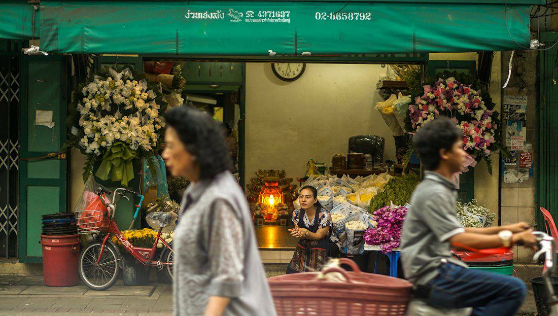 Local flower shop and passers-by on a Bangkok street