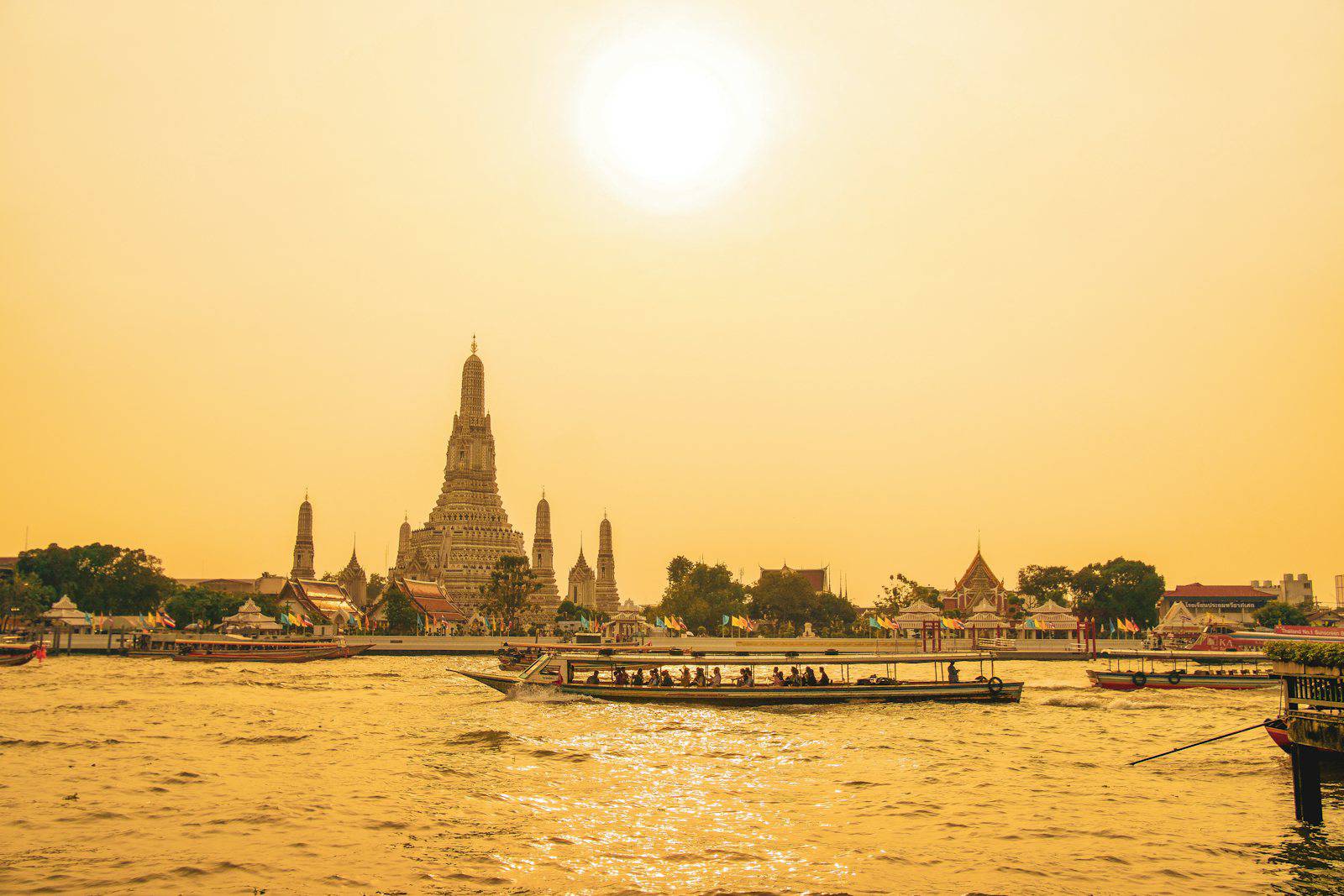Wat Arun and the Chao Phraya River in golden evening light