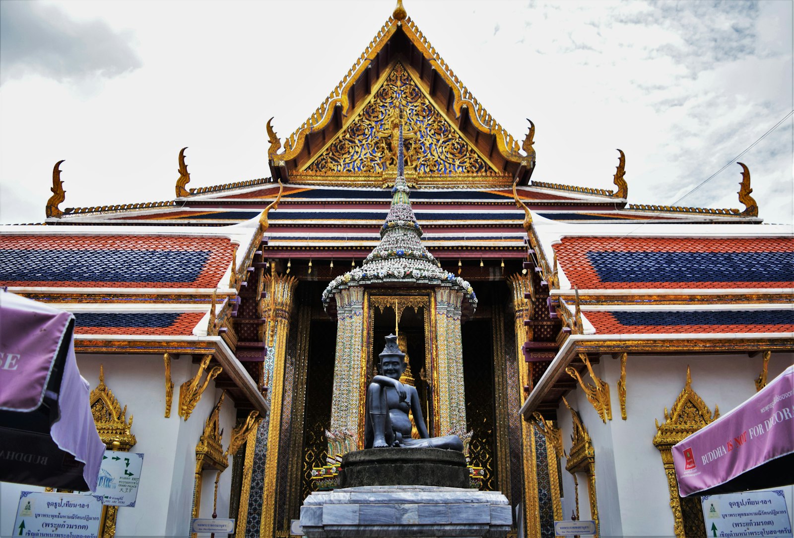 Gilded rooftops and mosaic pillars inside a Thai royal temple complex