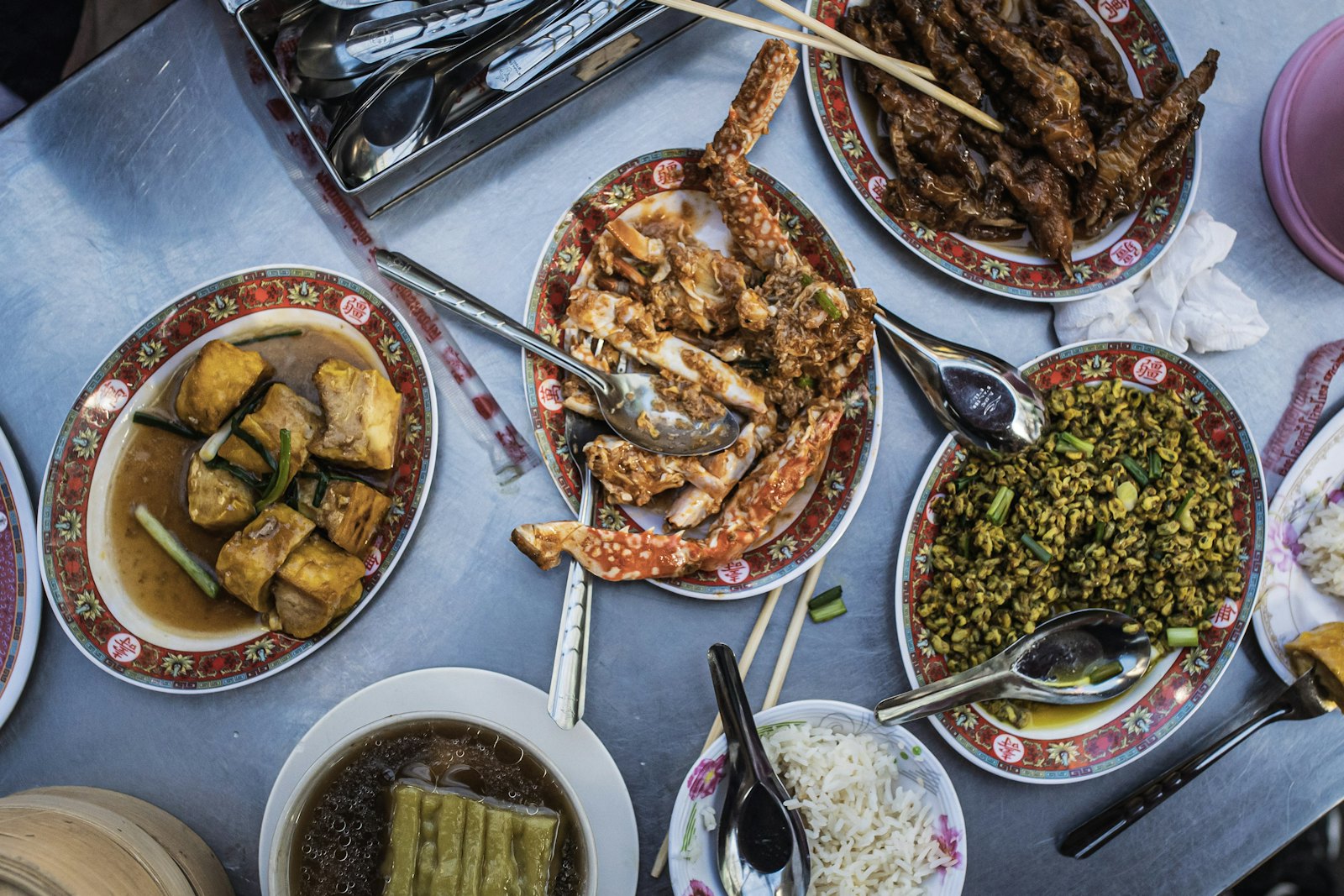 Plates of crab and other street food on a table in Bangkok's Chinatown