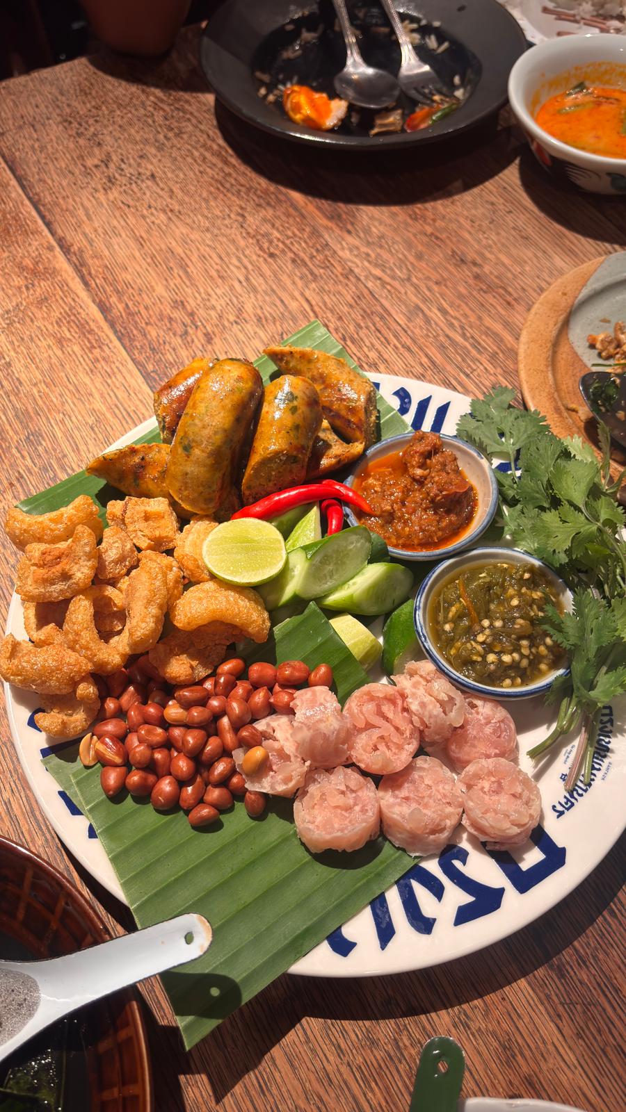 Northern Thai sharing platter with sai ua sausage, pork crackling and chilli dips at a restaurant in Asok, Bangkok